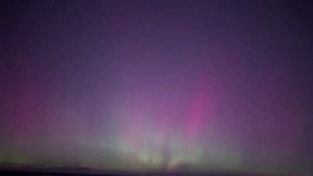 Aurora lights up night sky over Lake Michigan