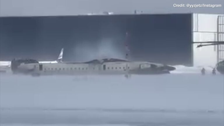 Witness video shows first responders tending to an upside-down Delta plane after crashing