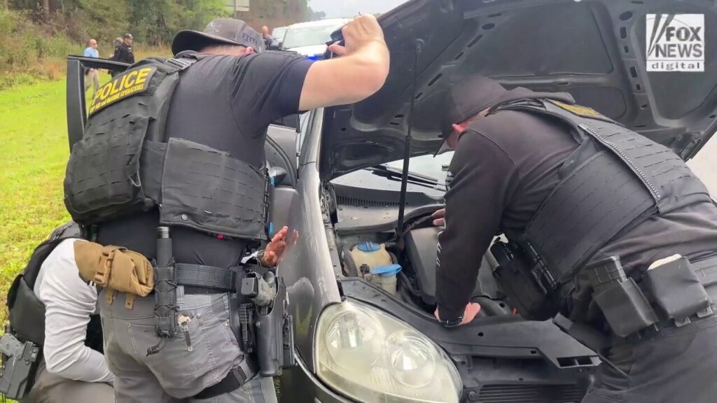 Law enforcement officers search suspects' vehicle for illicit drugs