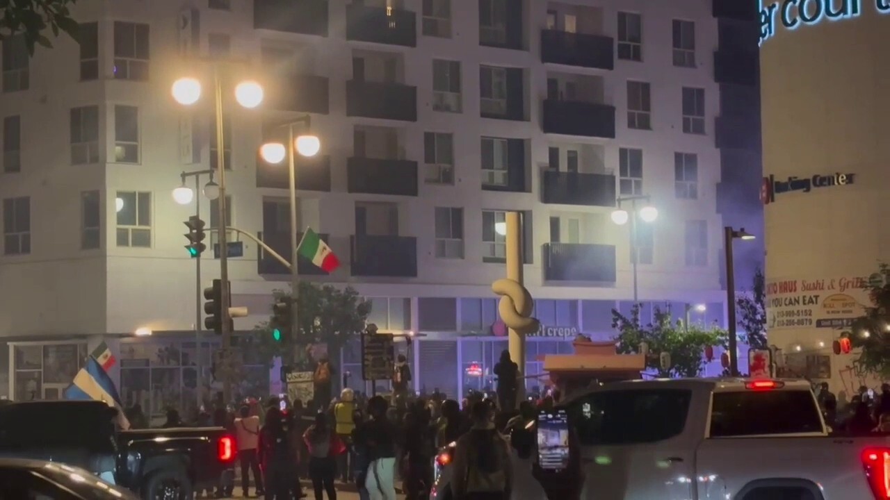 Protestors flee downtown Los Angeles street corner after police deploy tear gas