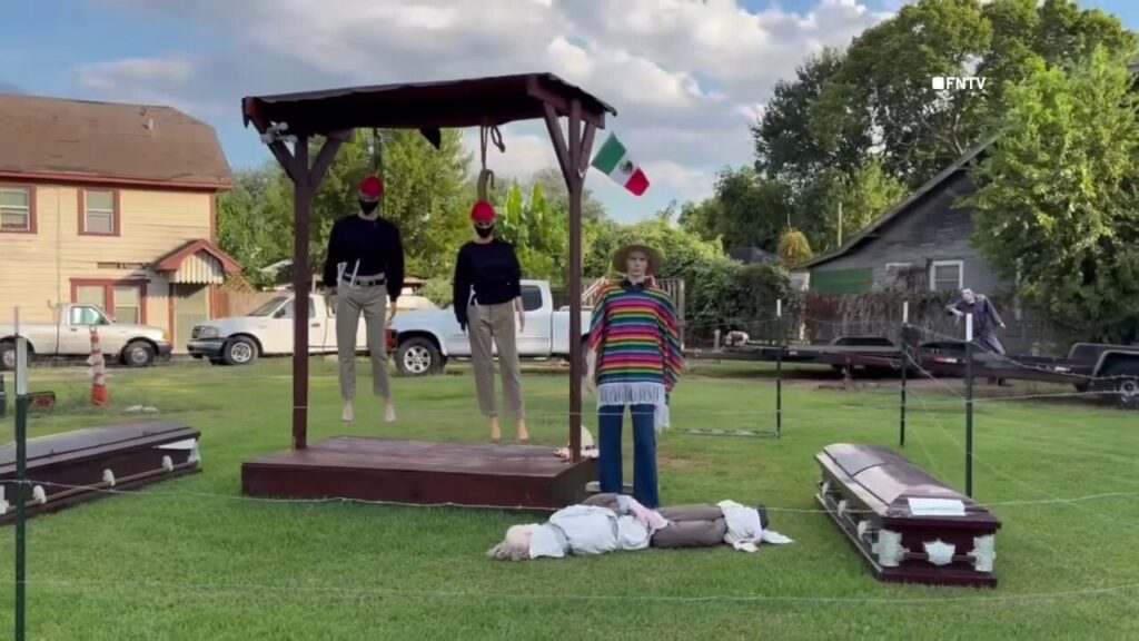 Mannequins dressed in red hats hang from gallows in Houston Halloween display