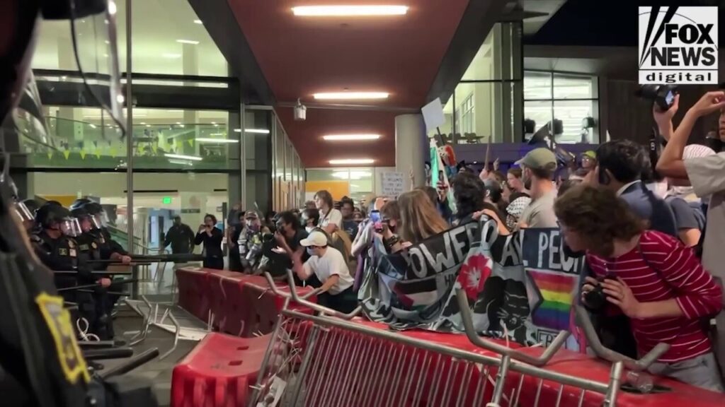 Police hold agitators back with barricades outside Berkeley TPUSA event